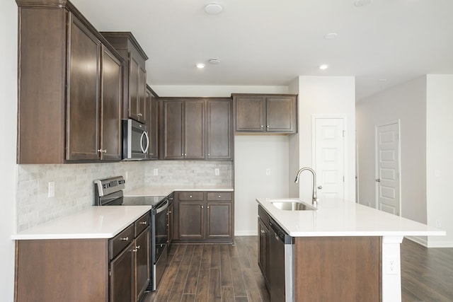 kitchen featuring dark wood-type flooring, an island with sink, stainless steel appliances, and sink