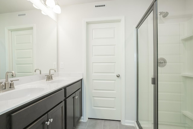 bathroom featuring tile patterned flooring, vanity, and walk in shower