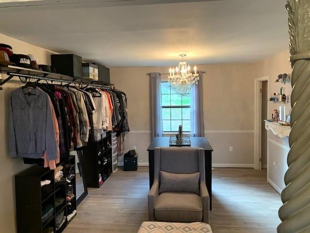 walk in closet with a chandelier and light wood-type flooring