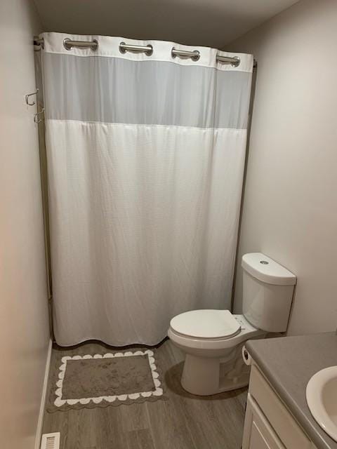 bathroom with vanity, hardwood / wood-style floors, and toilet