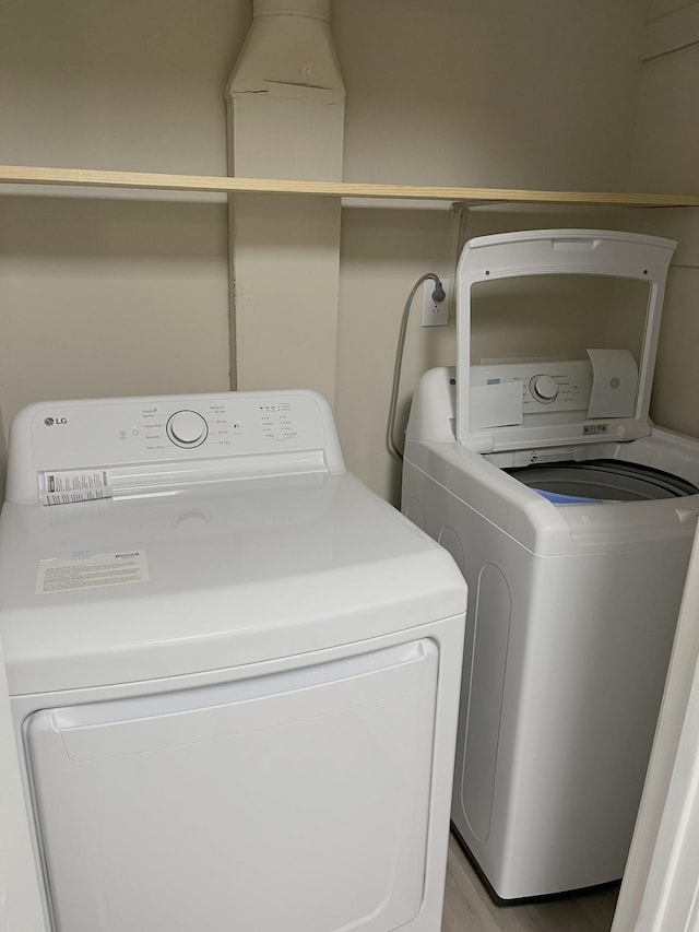 washroom with separate washer and dryer and light hardwood / wood-style floors