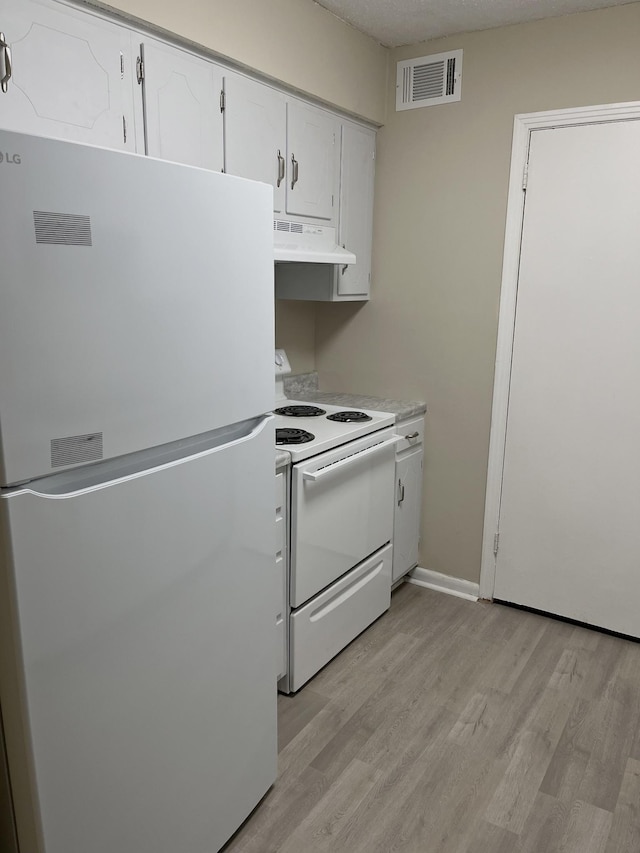 kitchen with white appliances, light wood-type flooring, and white cabinets