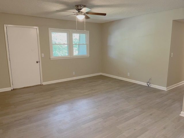 empty room with ceiling fan, a textured ceiling, and light wood-type flooring