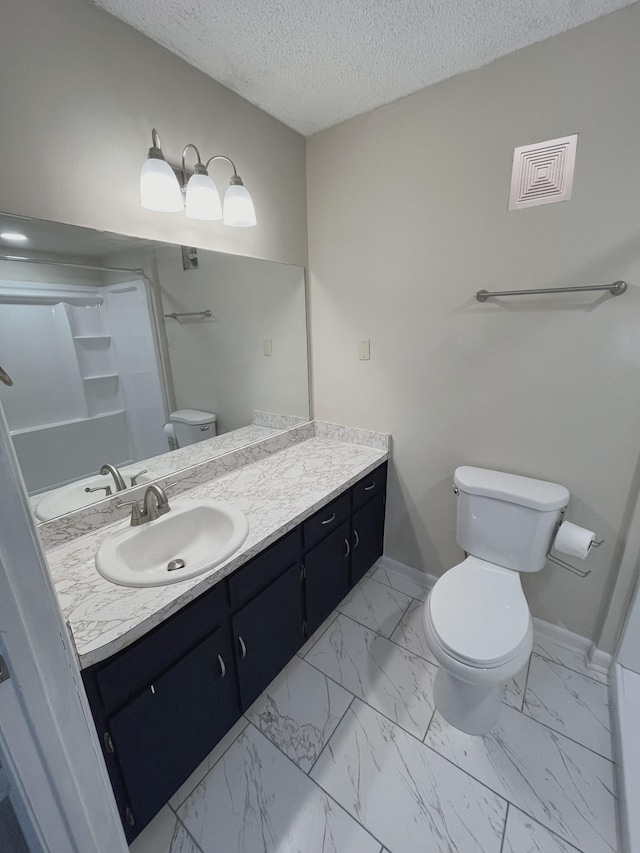 bathroom featuring vanity, toilet, and a textured ceiling