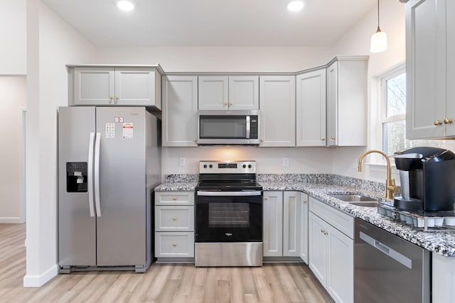 kitchen with light stone countertops, appliances with stainless steel finishes, and sink