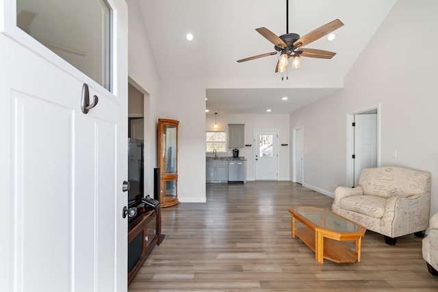 living room with ceiling fan, sink, hardwood / wood-style floors, and high vaulted ceiling