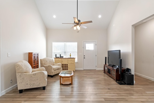 living room featuring vaulted ceiling, ceiling fan, and light hardwood / wood-style floors