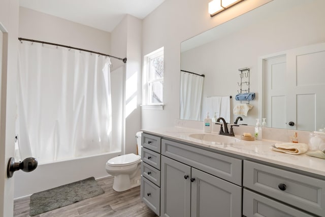 full bathroom with vanity, toilet, hardwood / wood-style floors, and shower / bath combo with shower curtain