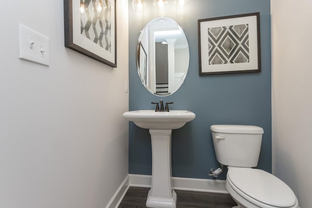 bathroom featuring wood-type flooring and toilet