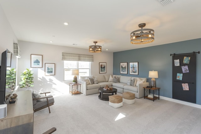 living room featuring an inviting chandelier, light colored carpet, and a barn door