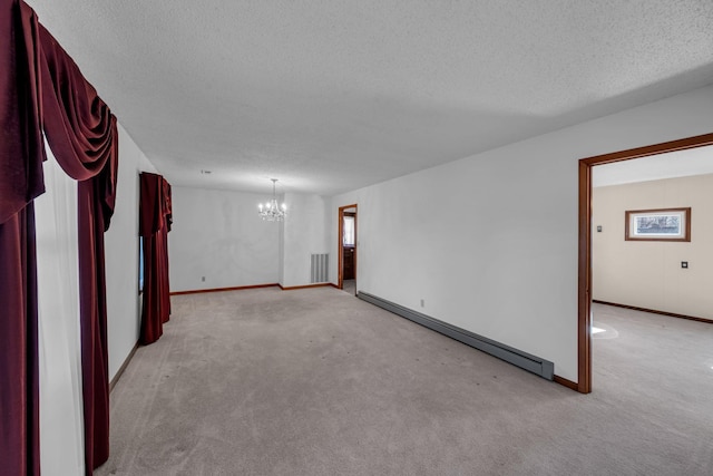 carpeted spare room with a baseboard radiator, a textured ceiling, and an inviting chandelier