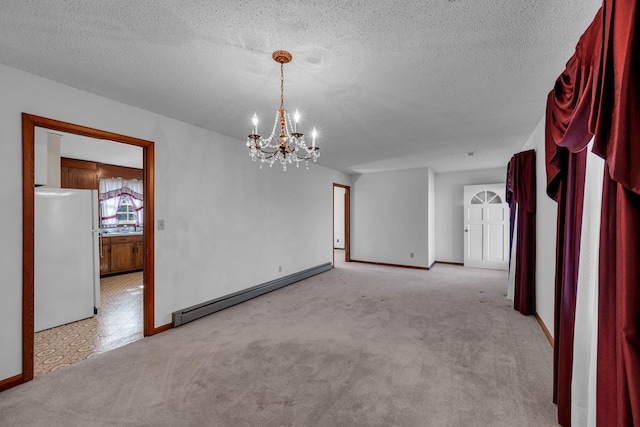 unfurnished room featuring a chandelier, light colored carpet, a textured ceiling, and baseboard heating