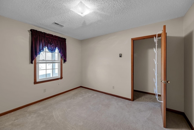 carpeted spare room with a textured ceiling