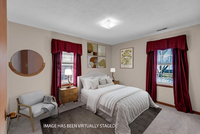 bedroom featuring light carpet and a textured ceiling