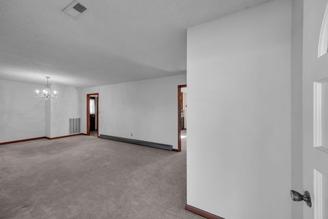 spare room with light carpet, a notable chandelier, a textured ceiling, and baseboard heating