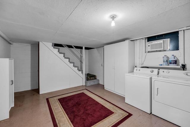 laundry room featuring separate washer and dryer, an AC wall unit, and a textured ceiling