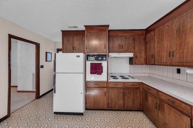 kitchen featuring mail boxes, white appliances, and a textured ceiling