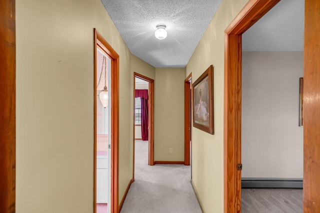 hall featuring a baseboard radiator, light carpet, and a textured ceiling