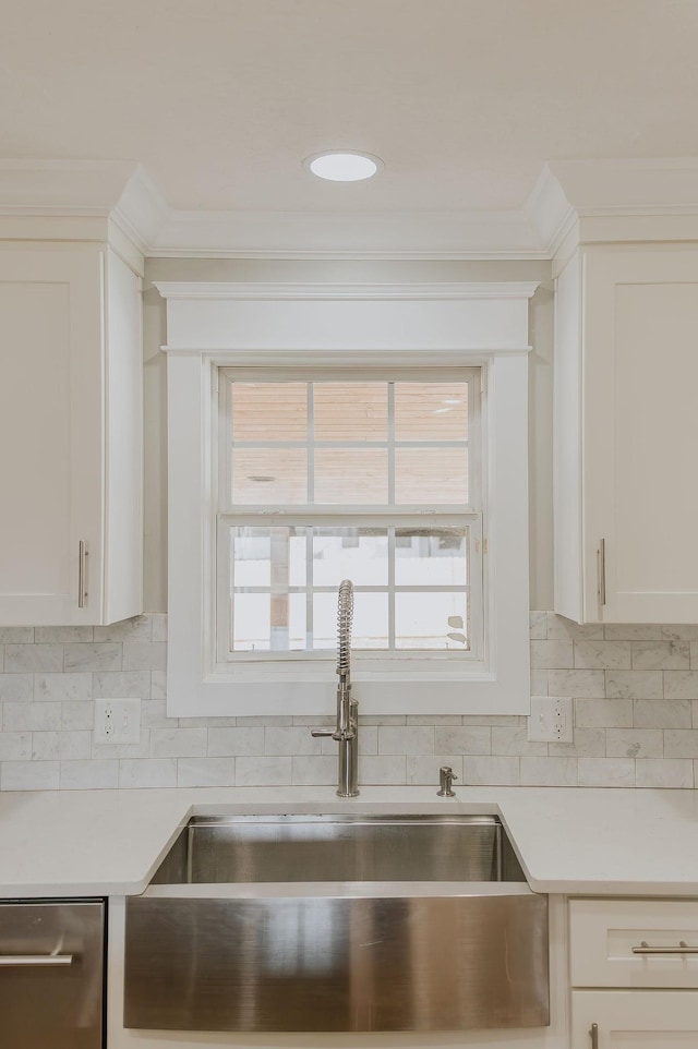 kitchen with sink, white cabinetry, ornamental molding, decorative backsplash, and stainless steel dishwasher