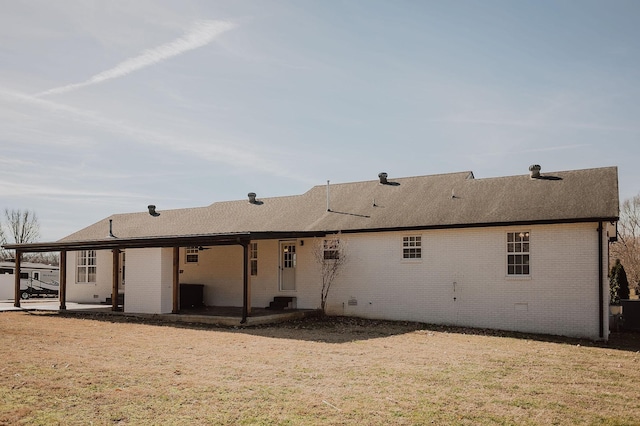 rear view of property featuring a lawn and a patio area