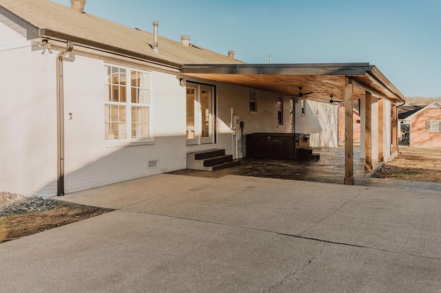 back of house featuring a hot tub and a patio