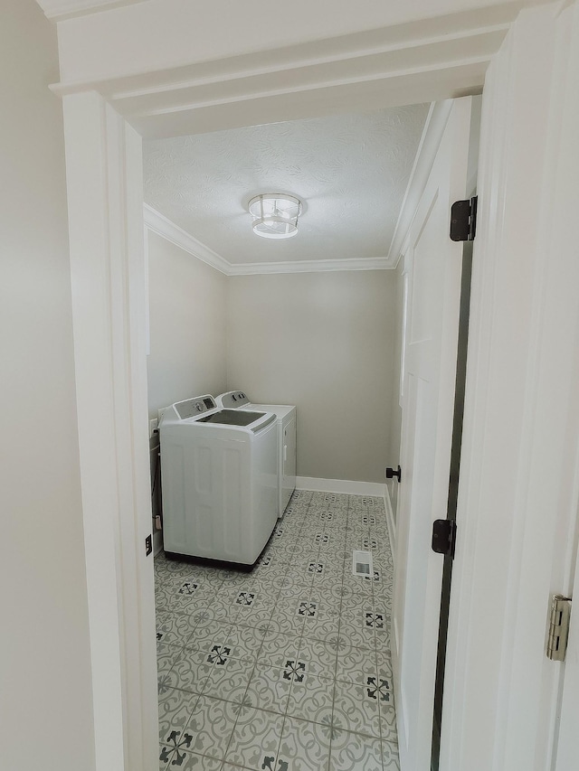 washroom featuring independent washer and dryer, ornamental molding, and a textured ceiling