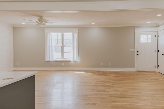 foyer entrance with ceiling fan, light hardwood / wood-style flooring, ornamental molding, and a healthy amount of sunlight