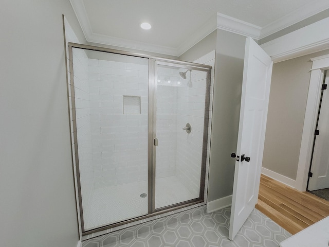 bathroom with ornamental molding and a shower with shower door