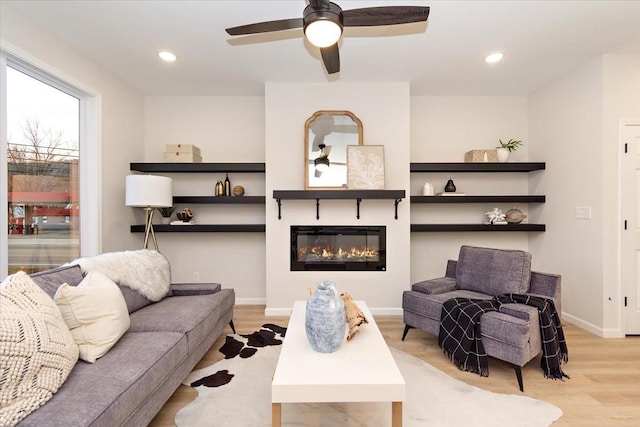 living room featuring light hardwood / wood-style flooring and ceiling fan