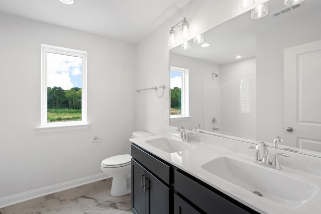 bathroom featuring walk in shower, vanity, and toilet