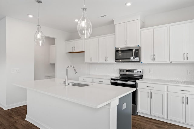 kitchen with stainless steel appliances, an island with sink, sink, and white cabinets