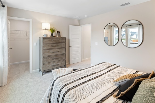 carpeted bedroom featuring a spacious closet and a closet