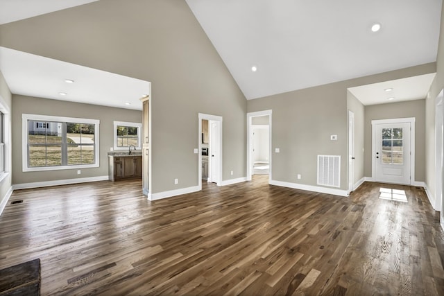 unfurnished living room with high vaulted ceiling, sink, and dark hardwood / wood-style flooring