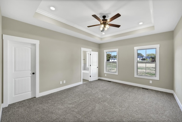 unfurnished bedroom with a raised ceiling, crown molding, and carpet floors