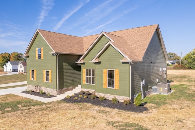 view of side of home with a lawn and central air condition unit