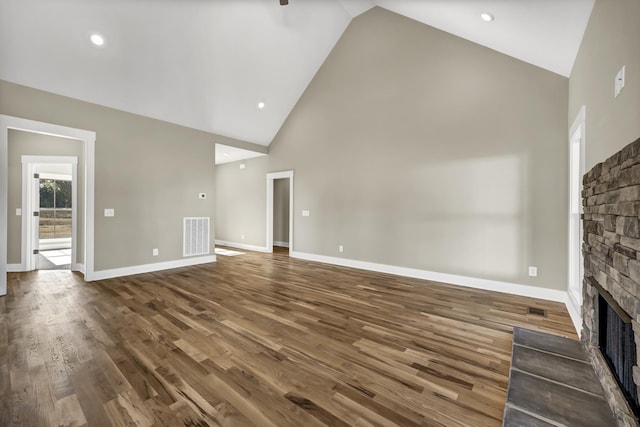 unfurnished living room featuring a fireplace, high vaulted ceiling, and wood-type flooring