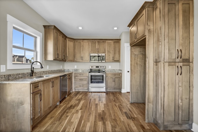 kitchen with light stone counters, stainless steel appliances, dark hardwood / wood-style flooring, and sink