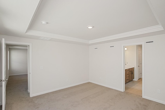 carpeted spare room with a tray ceiling and crown molding