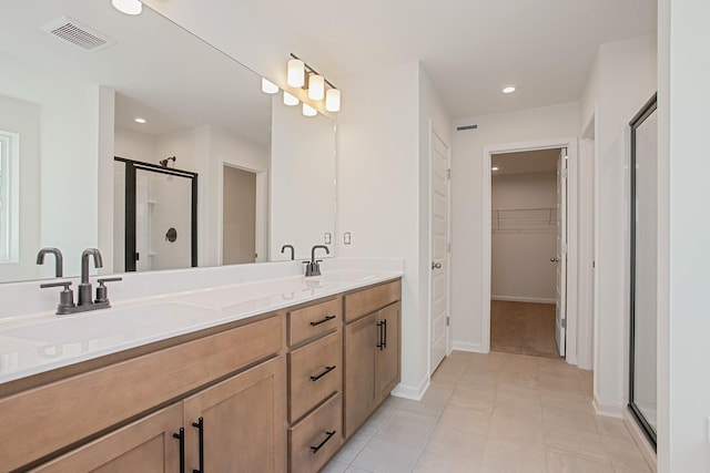 bathroom with an enclosed shower, vanity, and tile patterned floors