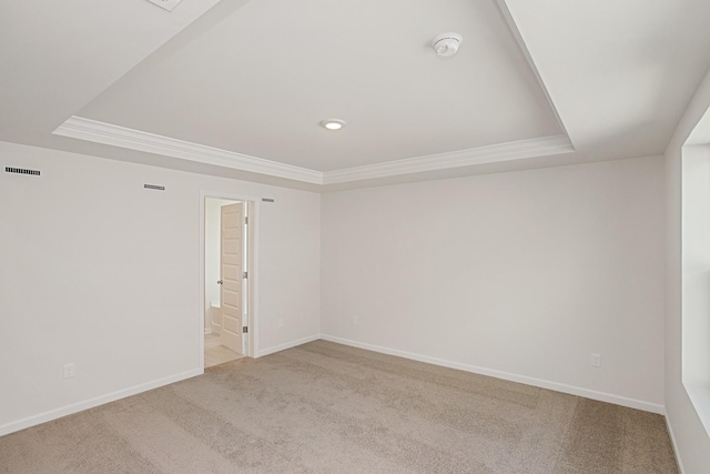 spare room with a raised ceiling, ornamental molding, and carpet flooring