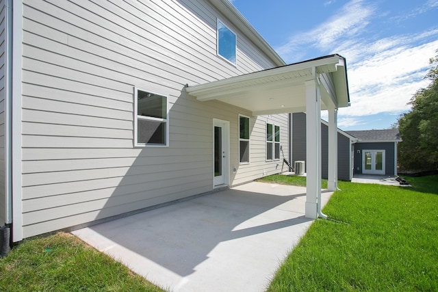 rear view of house featuring central AC, a lawn, a patio, and french doors