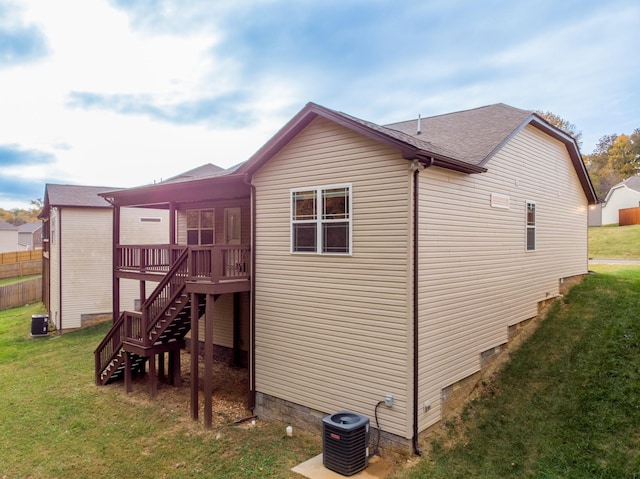 exterior space with central AC, a wooden deck, and a lawn