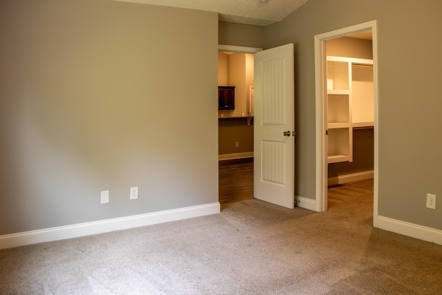 unfurnished bedroom featuring carpet flooring and a spacious closet