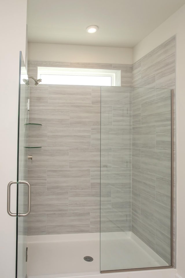 bathroom featuring a shower with shower door