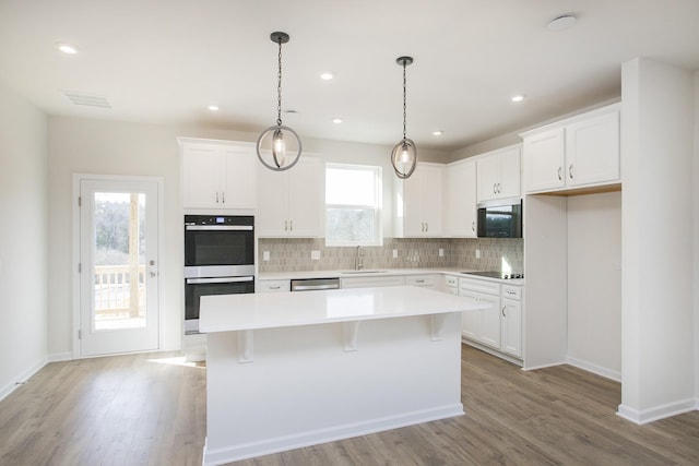 kitchen featuring appliances with stainless steel finishes, a center island, and white cabinets