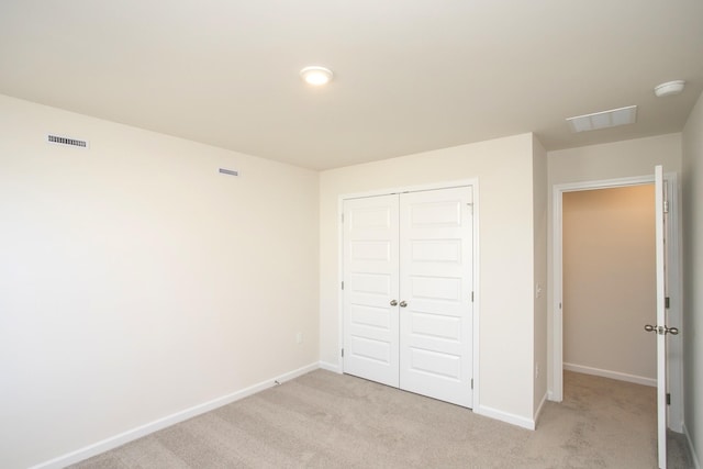 unfurnished bedroom with a closet and light carpet