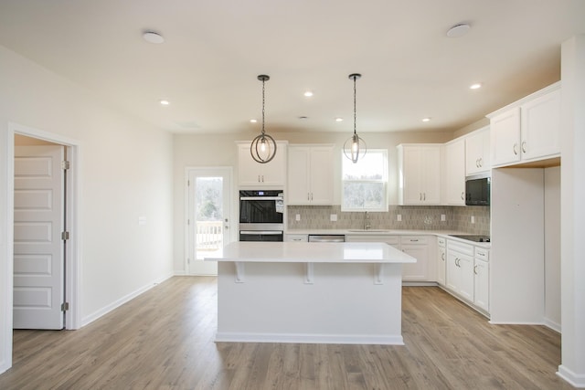 kitchen with black appliances, a kitchen island, and white cabinets