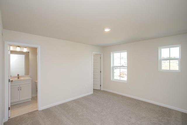 unfurnished room featuring sink and light colored carpet