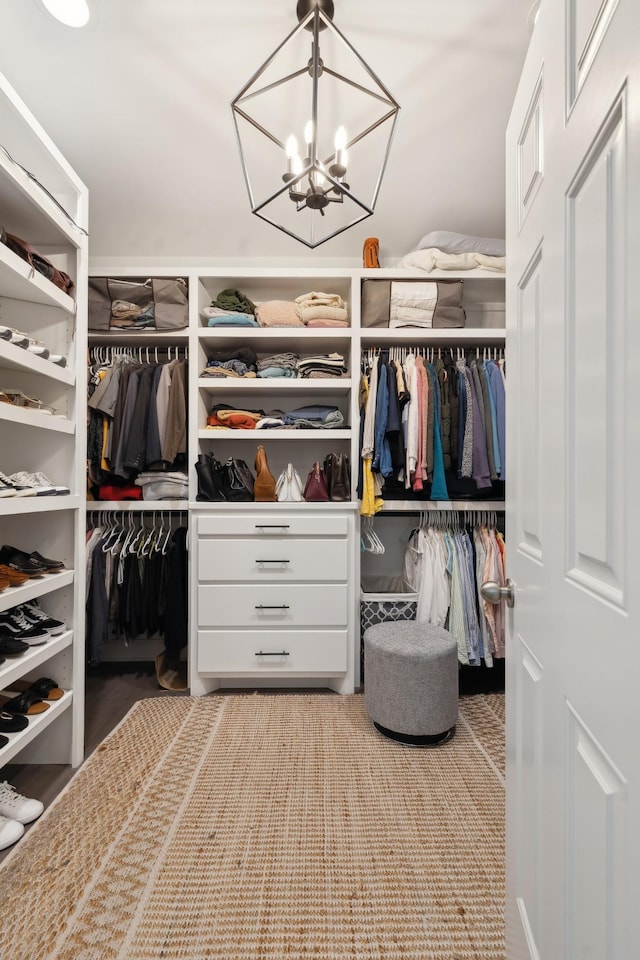 spacious closet with an inviting chandelier