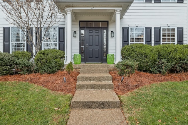 doorway to property with a lawn